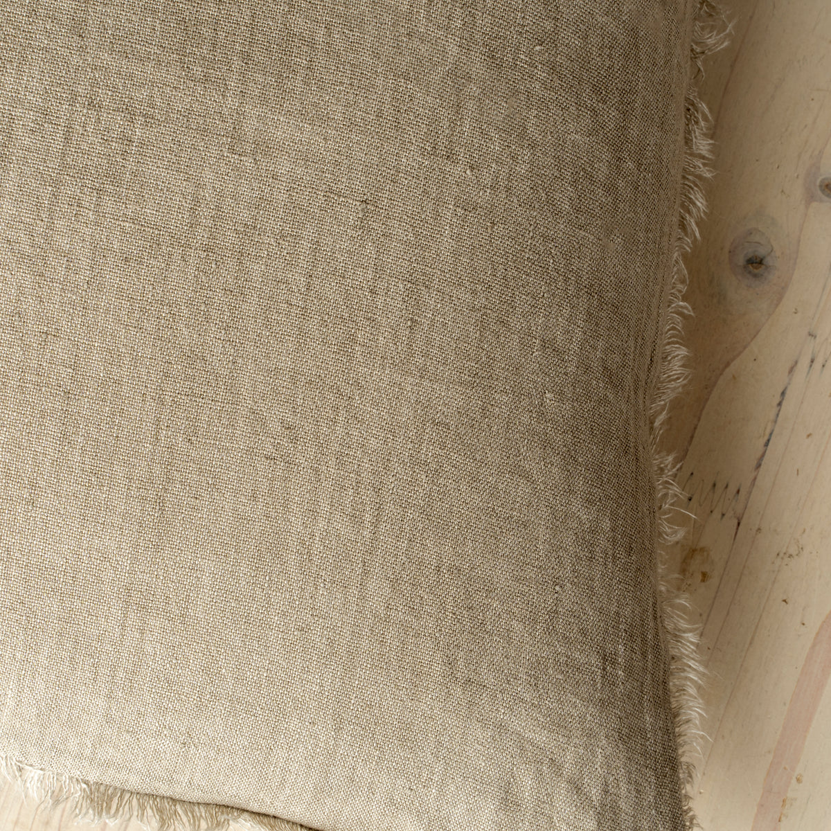 Macro close-up of the Lina linen pillow showcasing the breathable fabric and the delicate frayed fringe edge