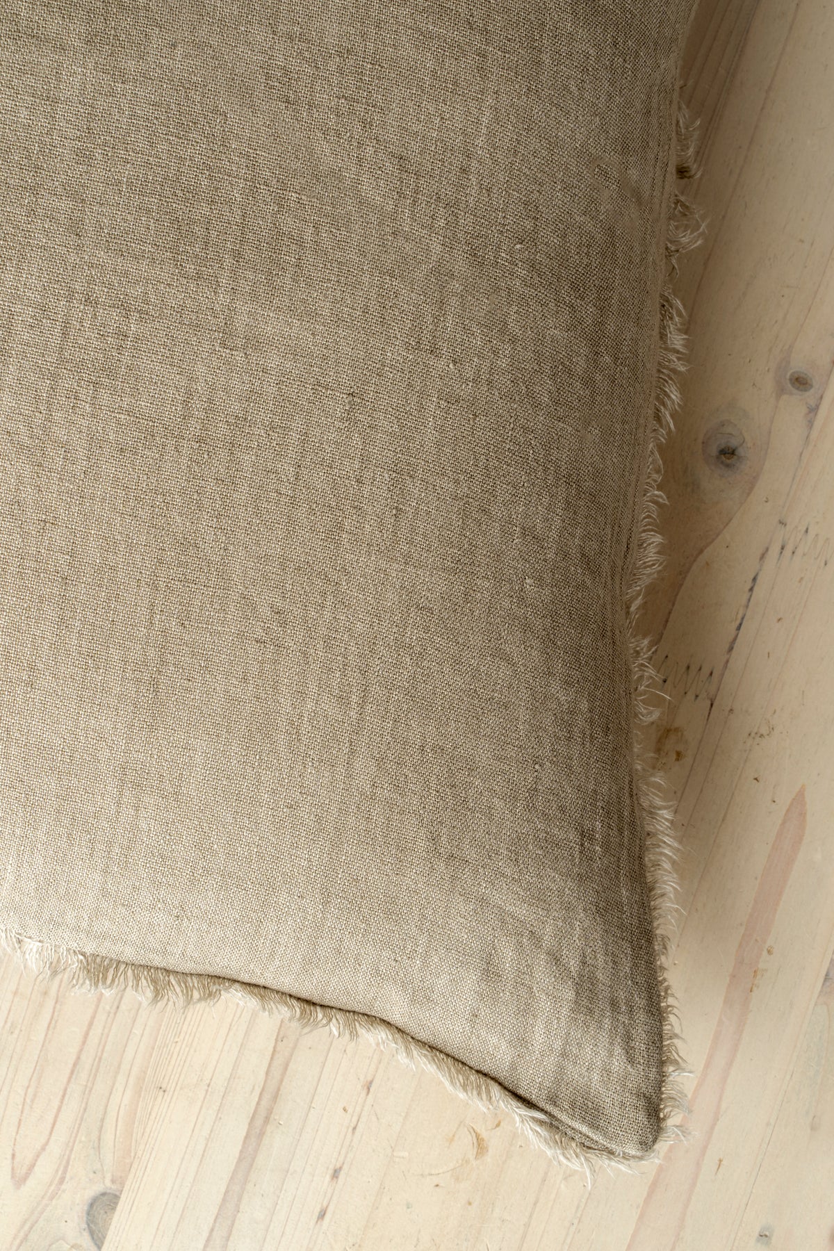 Macro close-up of the Lina linen pillow showcasing the breathable fabric and the delicate frayed fringe edge
