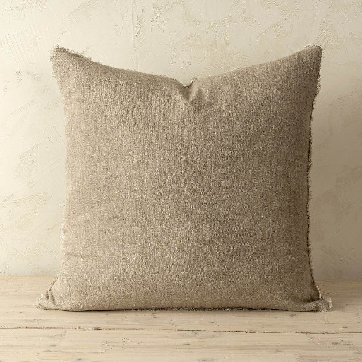Full front view of the Lina linen pillow featuring a natural raw-edge fringe detail.