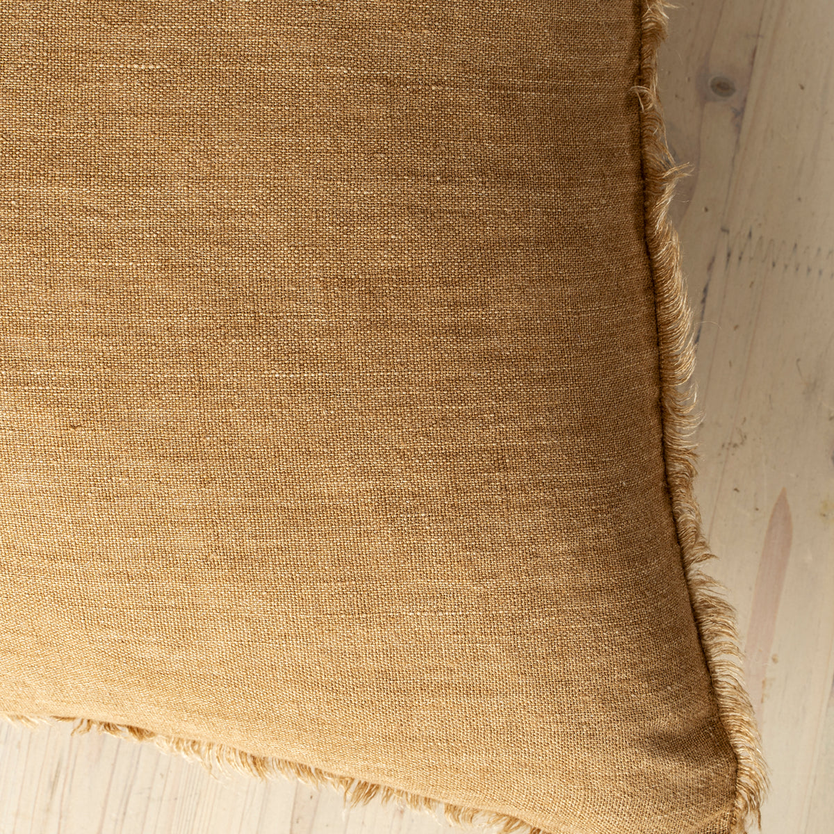 Macro close-up of the Lina linen pillow showcasing the breathable fabric and the delicate frayed fringe edge