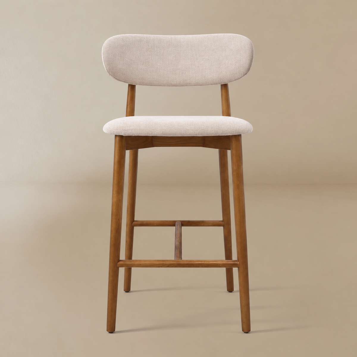 Linen ash wood bar stool with a light beige upholstered seat and backrest, supported by a warm medium-brown wooden frame with a curved top rail and footrest, set against a solid beige background.