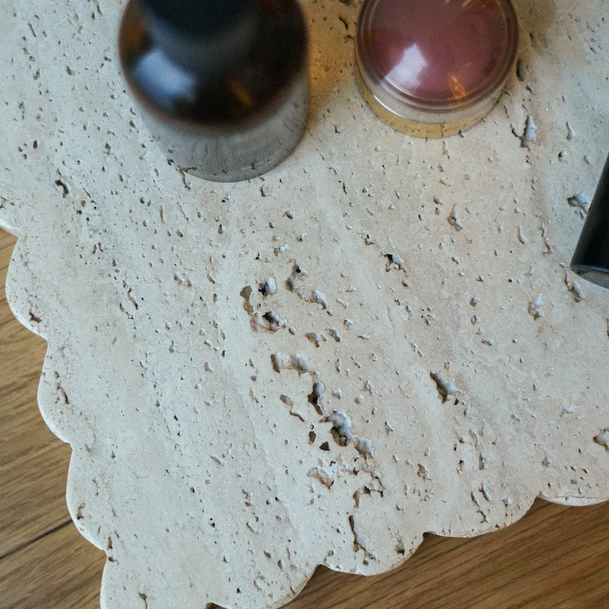 Two bottles on a textured white surface with a wooden background
