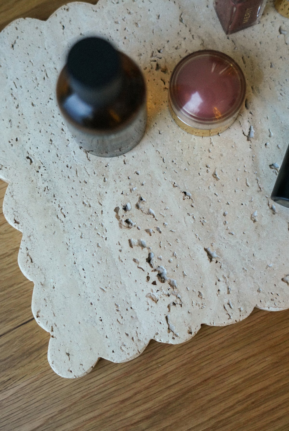 Two bottles on a textured white surface with a wooden background