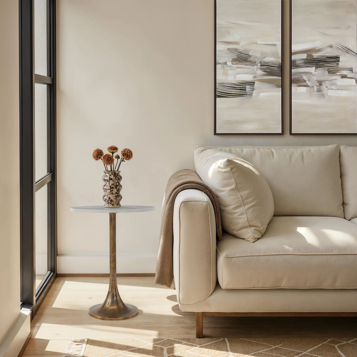 Modern living room with beige sofa, side table, and abstract wall art.