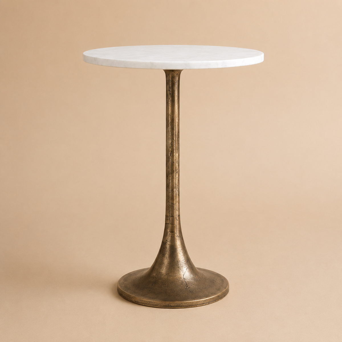 Round table with marble top and bronze base on a beige background