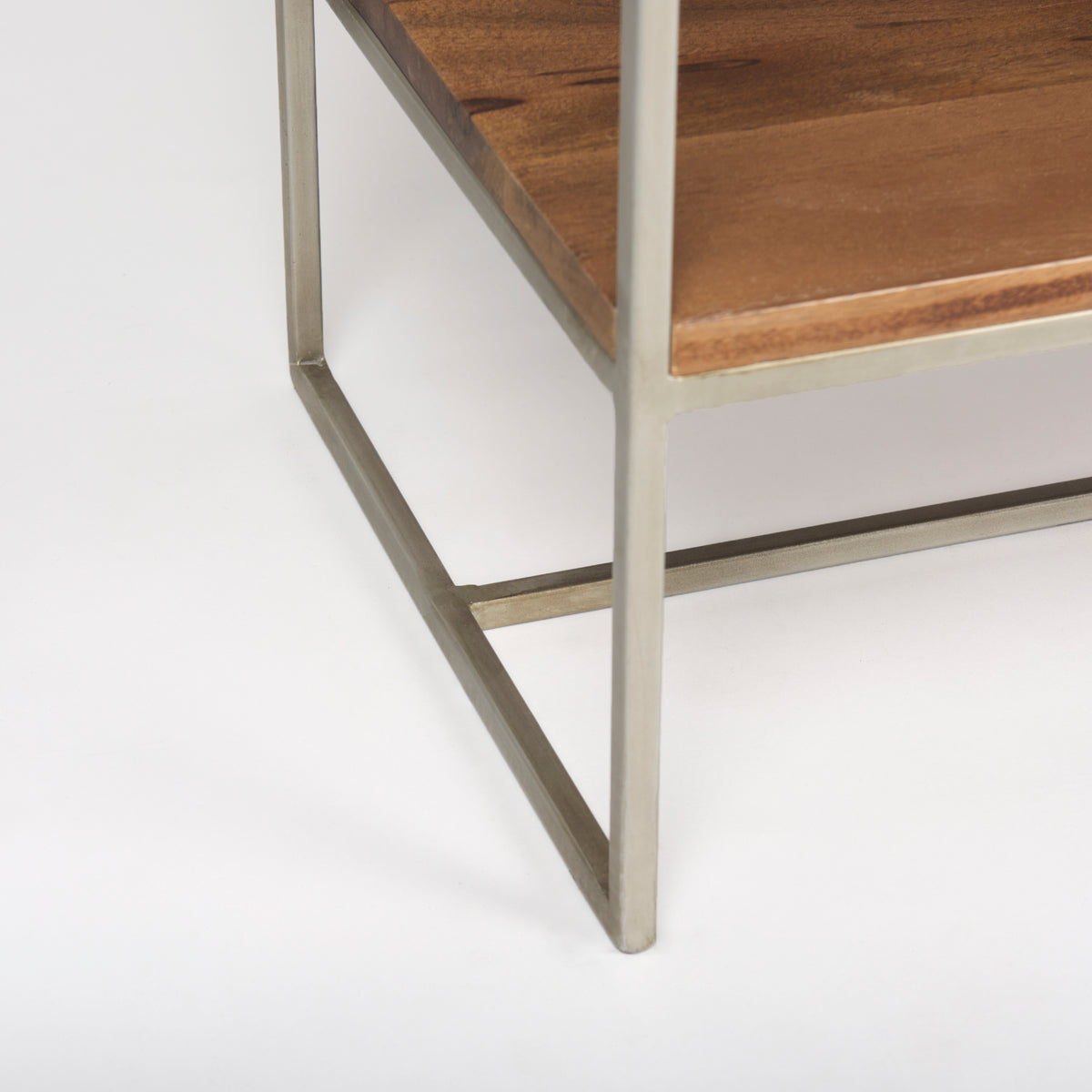Close-up of the bottom corner showing the silver metal frame and wooden base of the Maddox shelving unit.