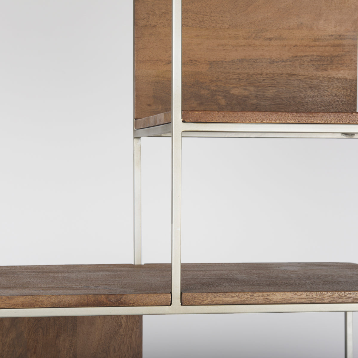 Macro detail showing the thick wooden shelf resting flush within the metal frame of the Maddox unit.
