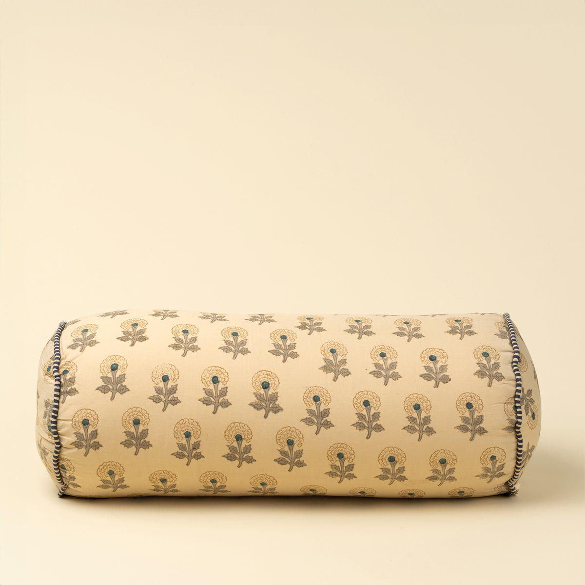 Decorative cylindrical pillow with floral pattern on a beige background