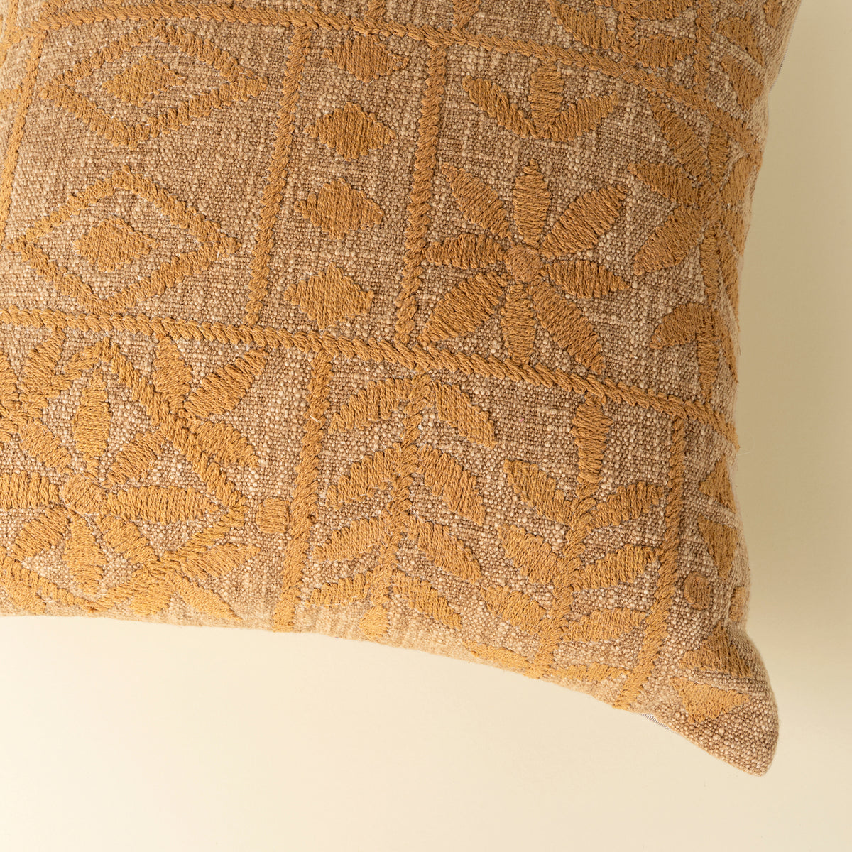 Textured pillow with geometric pattern on a beige background