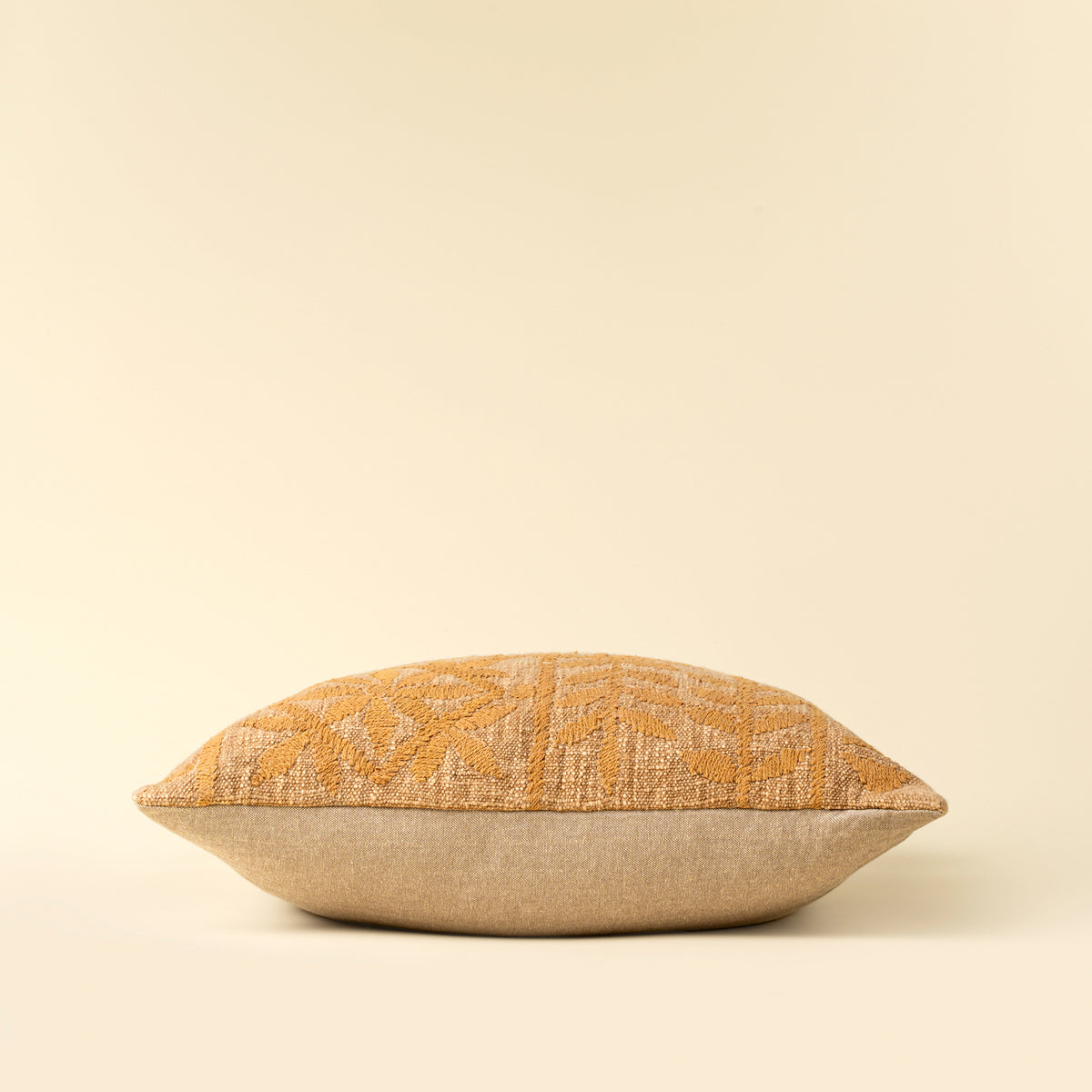 Decorative pillow with a textured pattern on a beige background