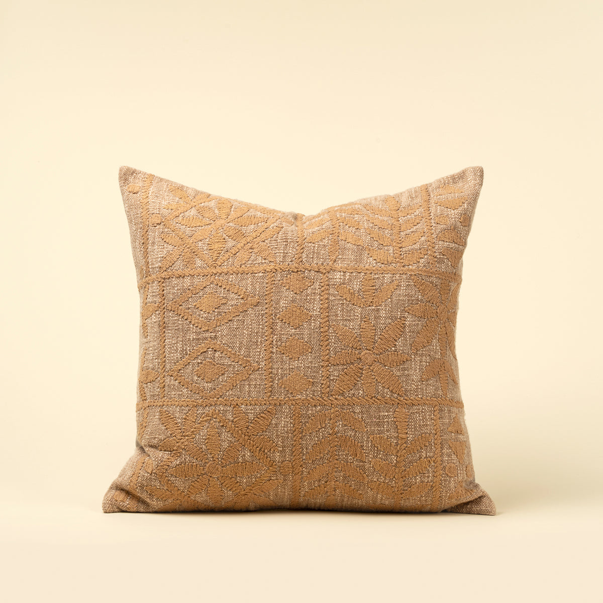 Textured pillow with geometric pattern on a beige background