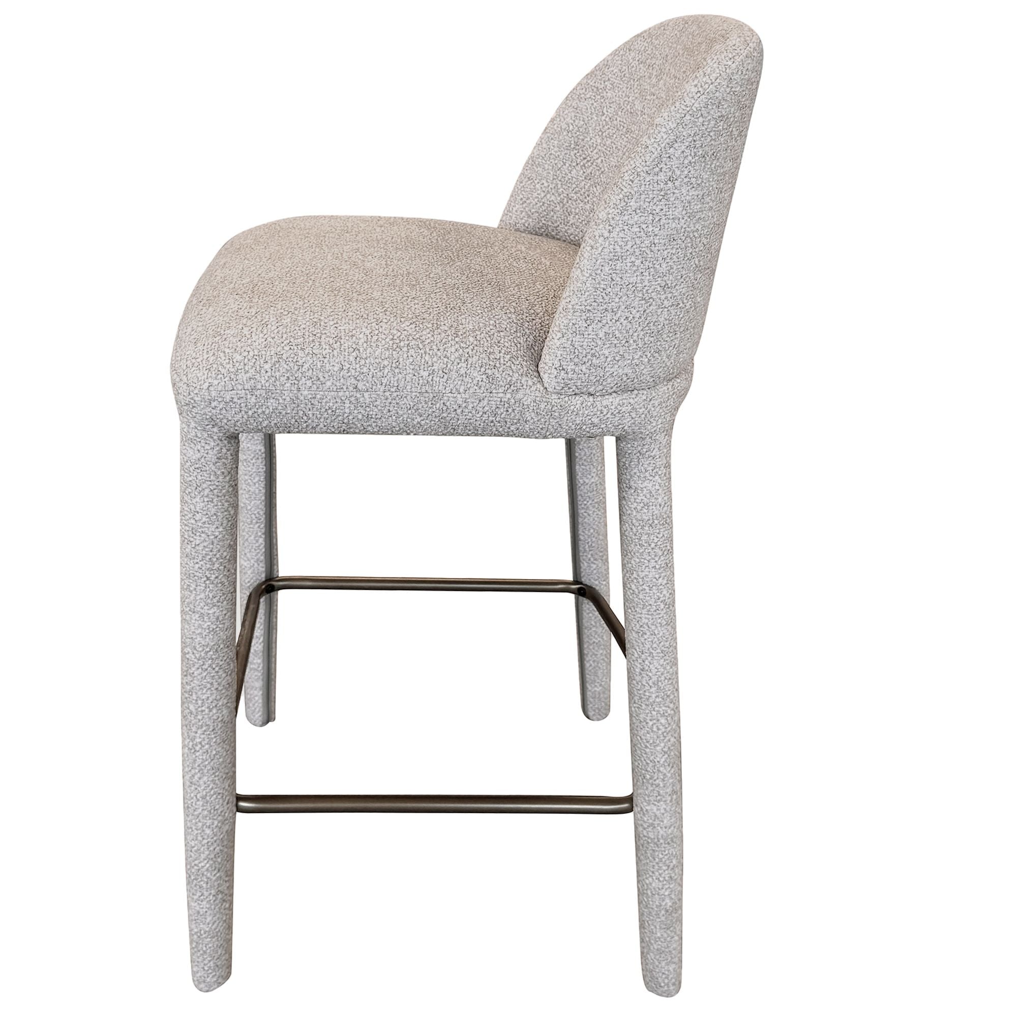 Side profile view of the Myla upholstered counter stool highlighting its thick seat, curved back, and sturdy fabric-wrapped legs.
