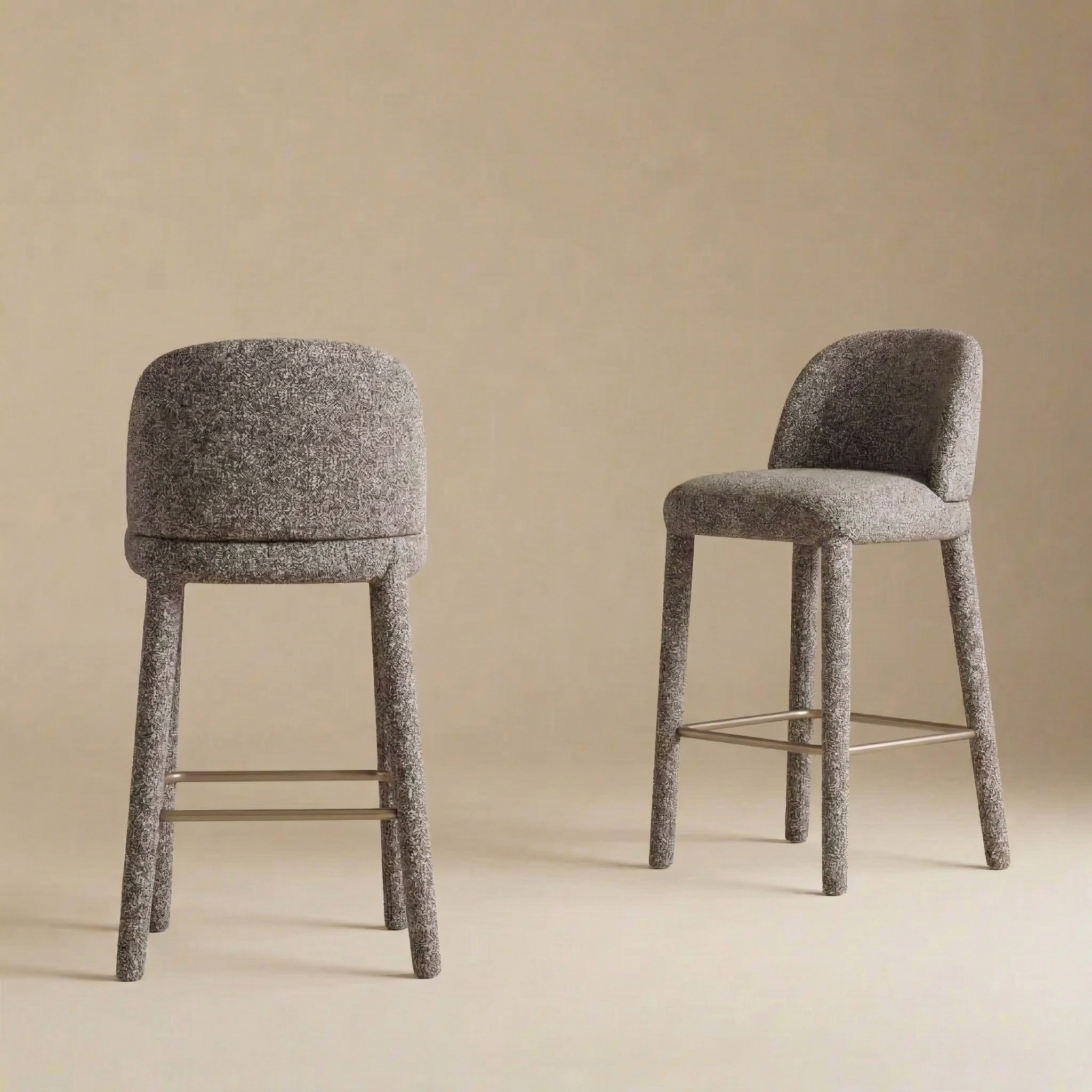 A pair of Myla upholstered counter stools showcasing their curved backrests and seamless light grey textured fabric.
