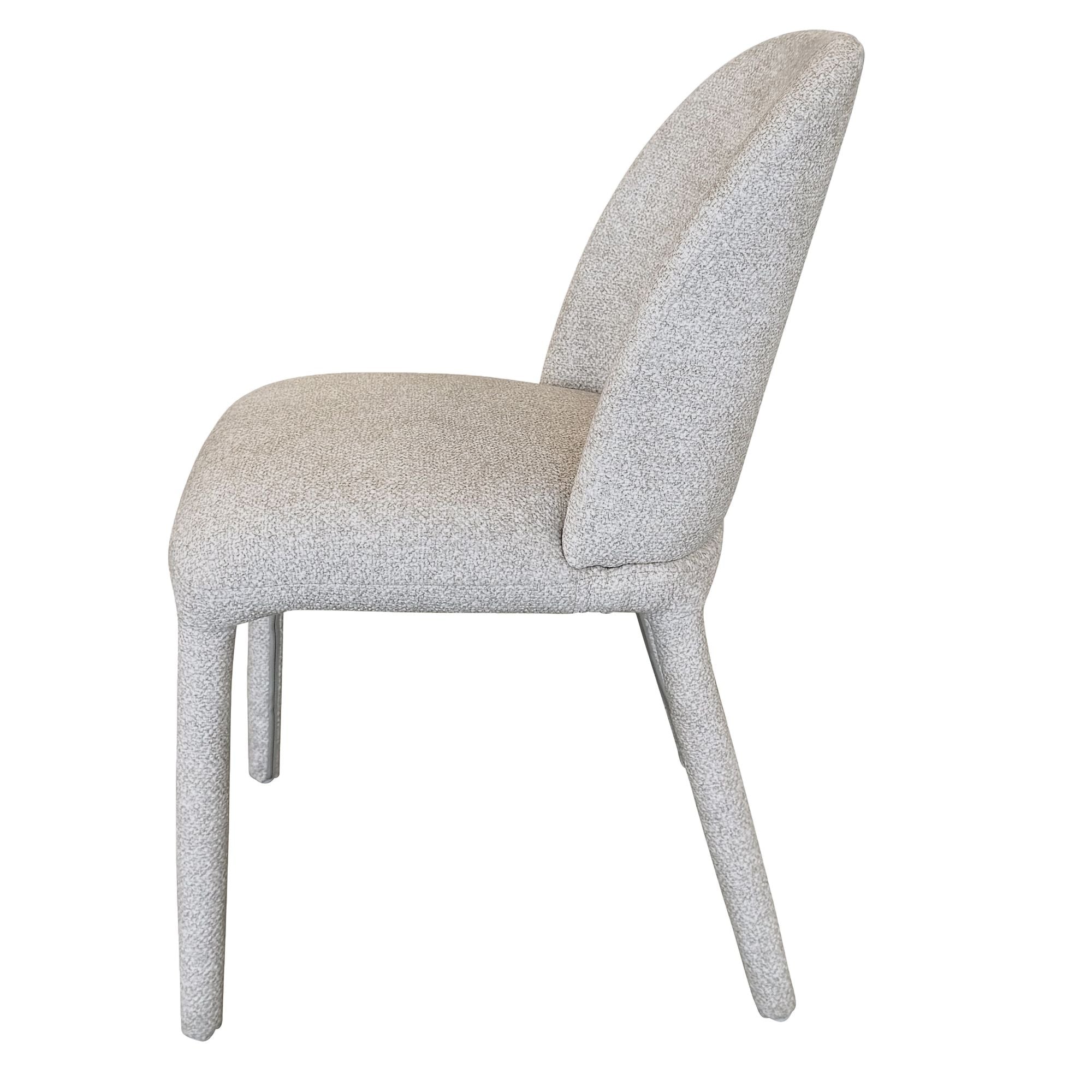 Side profile view of the beige Myla dining chair showcasing its curved hugging backrest and sturdy fabric-wrapped legs.