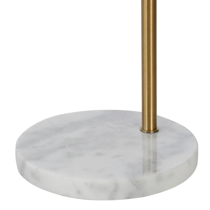 Close-up of the Noemi floor lamp's round white marble base and antique brass stem.