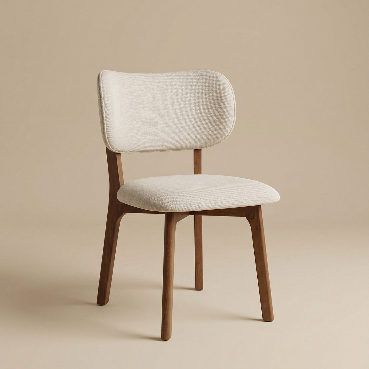 Angled view of the Nolan dining chair showing its elegant curved back silhouette and warm walnut-finished wood legs