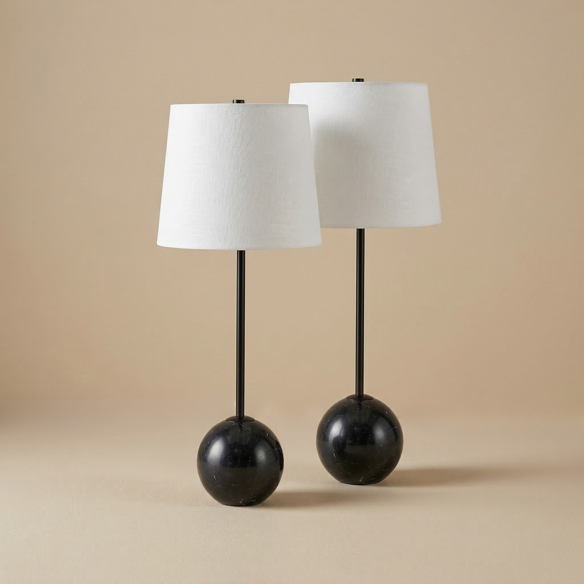 A pair of Nox table lamps featuring spherical black marble bases and matching minimalist black stems.