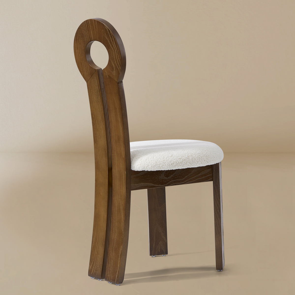 Angle view of the Obsidian Loop Dining Chair in a light beige studio background