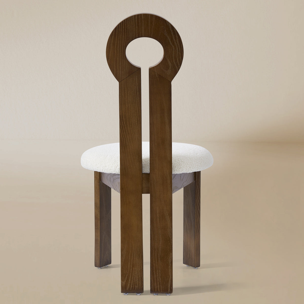 Back view of the Obsidian Loop Dining Chair in a light beige studio background