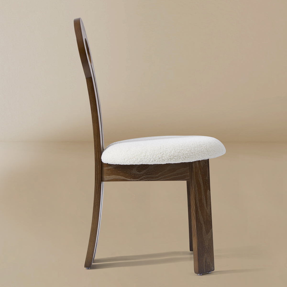 Side view of the Obsidian Loop Dining Chair in a light beige studio background