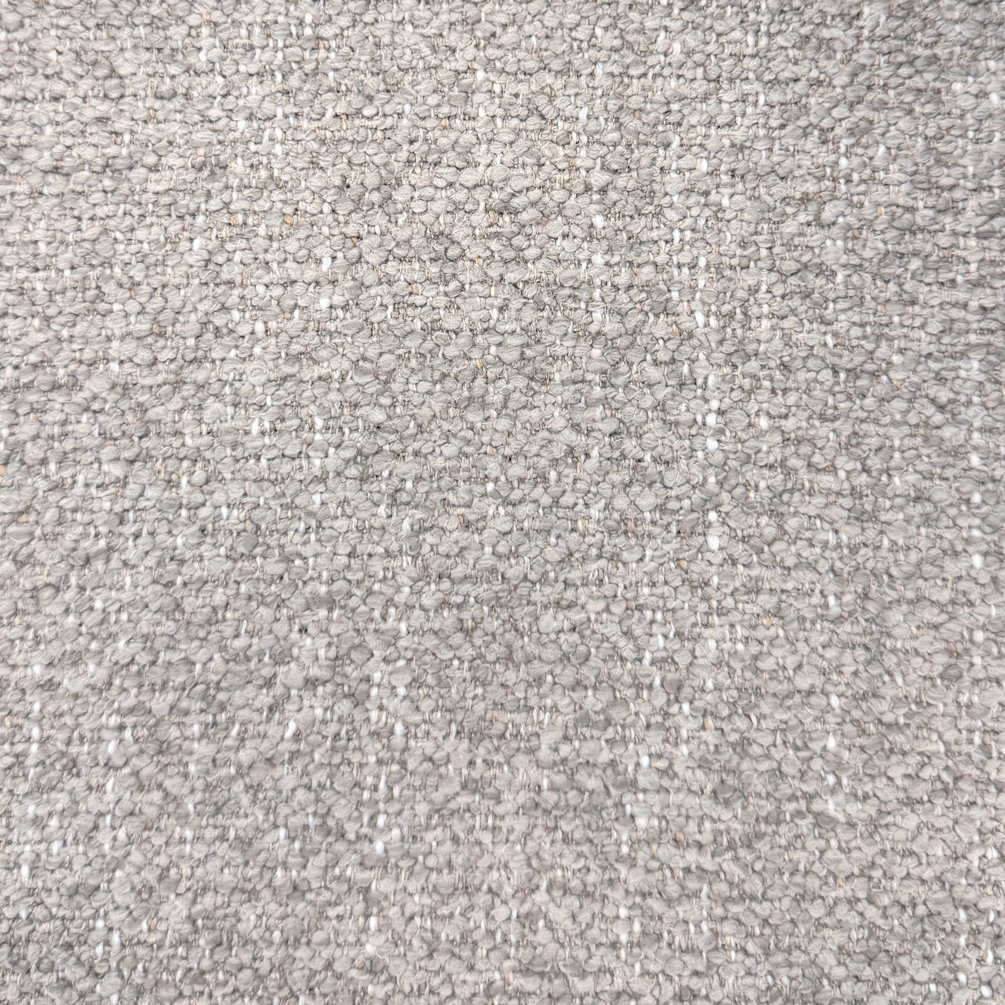 Macro close-up of the Odette chair's premium multi-tonal grey bouclé fabric highlighting its rich, nubby texture.