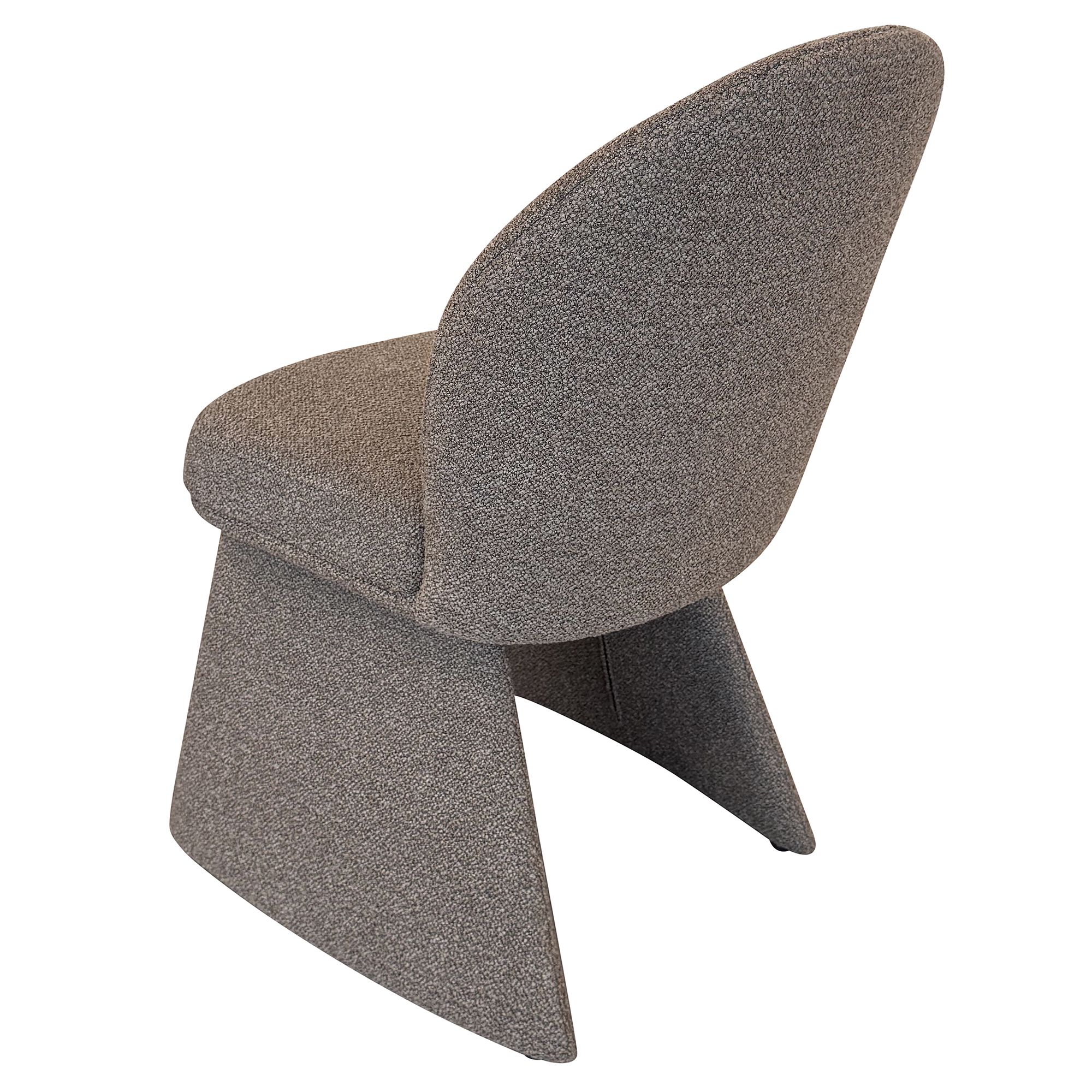 Rear angled studio view of the Odette chair in charcoal color fabric highlighting the seamless upholstery and sculptural tapering legs.