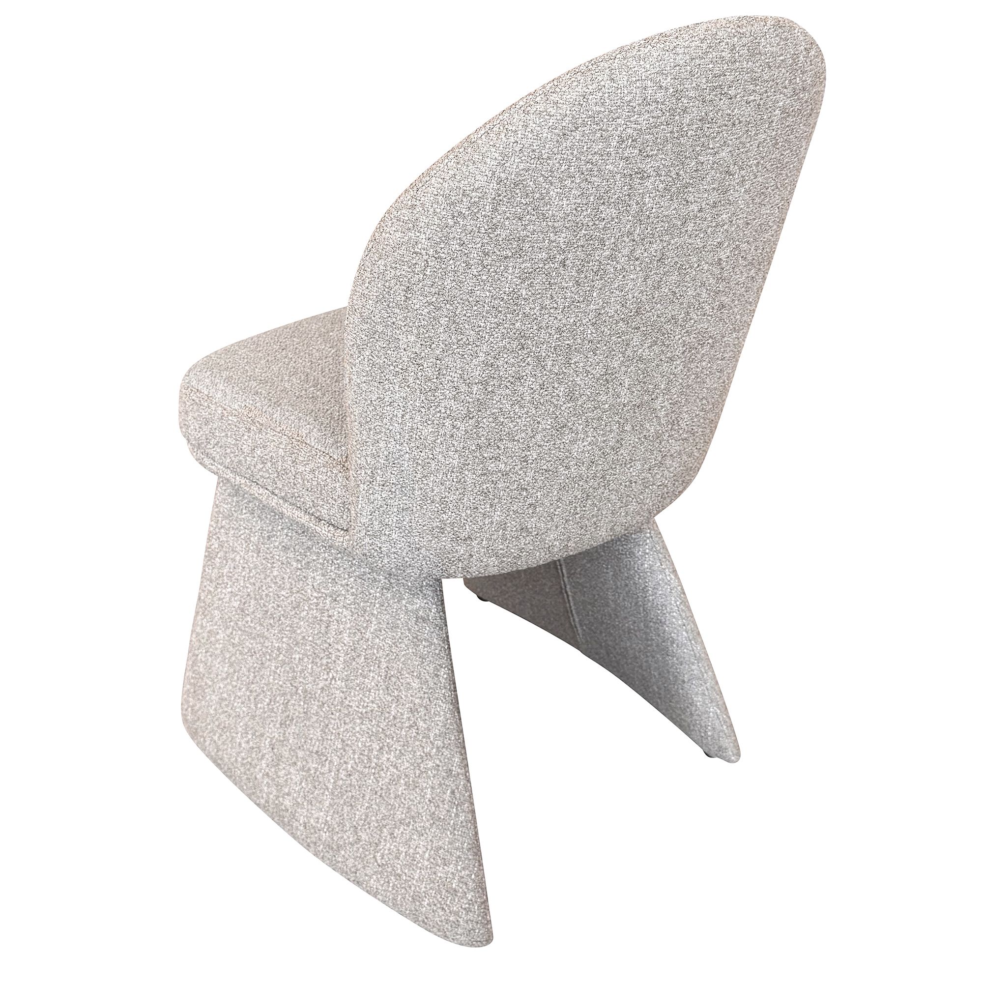 Rear angled studio view of the Odette chair highlighting the seamless upholstery and sculptural tapering legs.