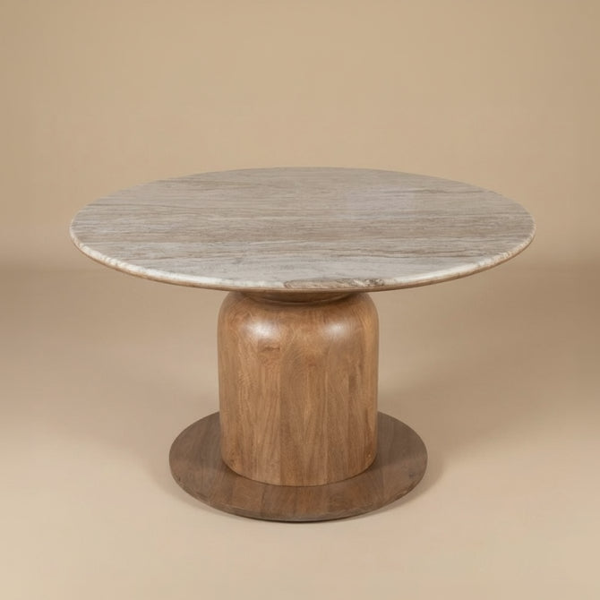 Ottilie round dining table with marble top and wooden base on beige studio background.