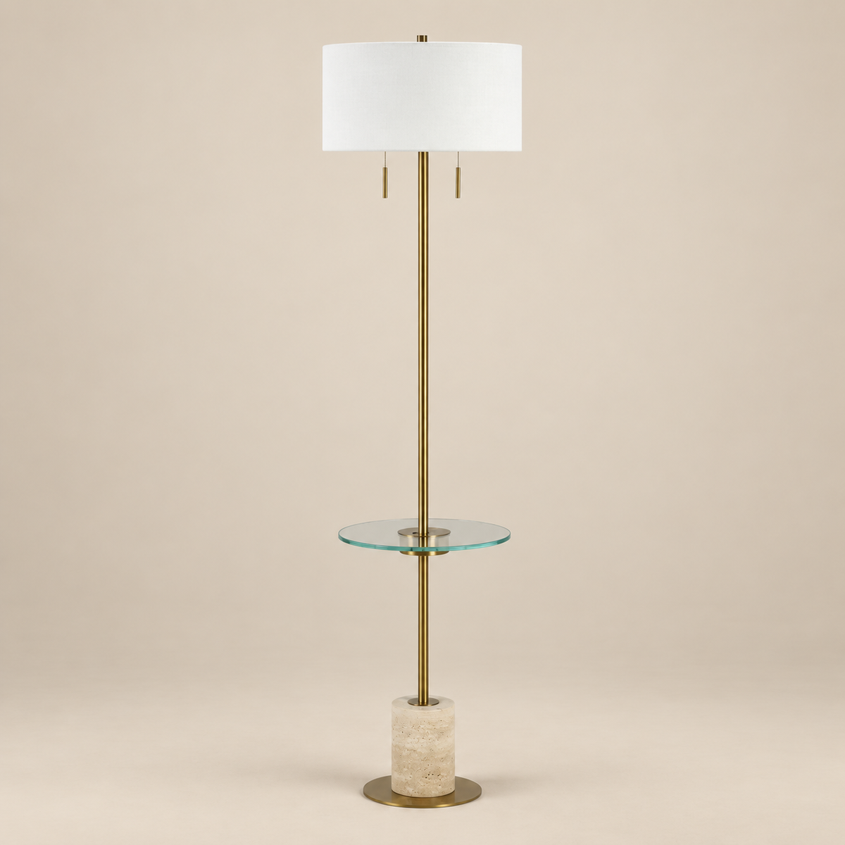 Perrin travertine shelf floor lamp featuring a plated antique brass frame, clear glass shelf, and off-white linen shade on a beige studio background.