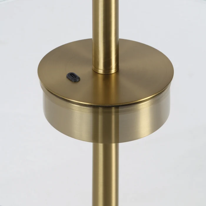 Close-up of the Perrin floor lamp's clear glass shelf and antique brass control detail.