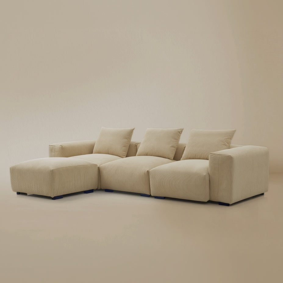 Angle view of the beige plush corduroy sectional with ottoman sofa in a studio background