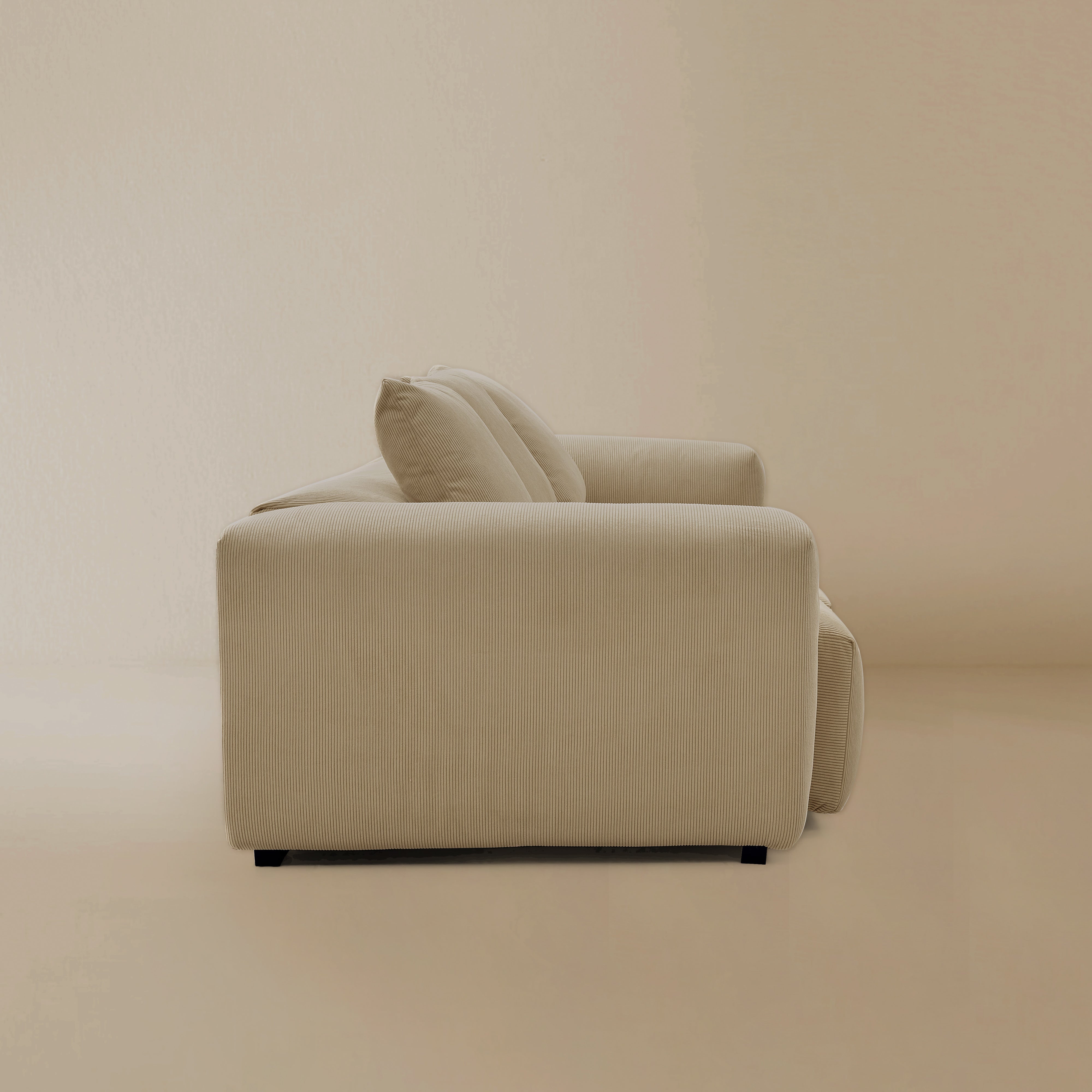 Side view fo the beige plush corduroy modular sofa in a studio background