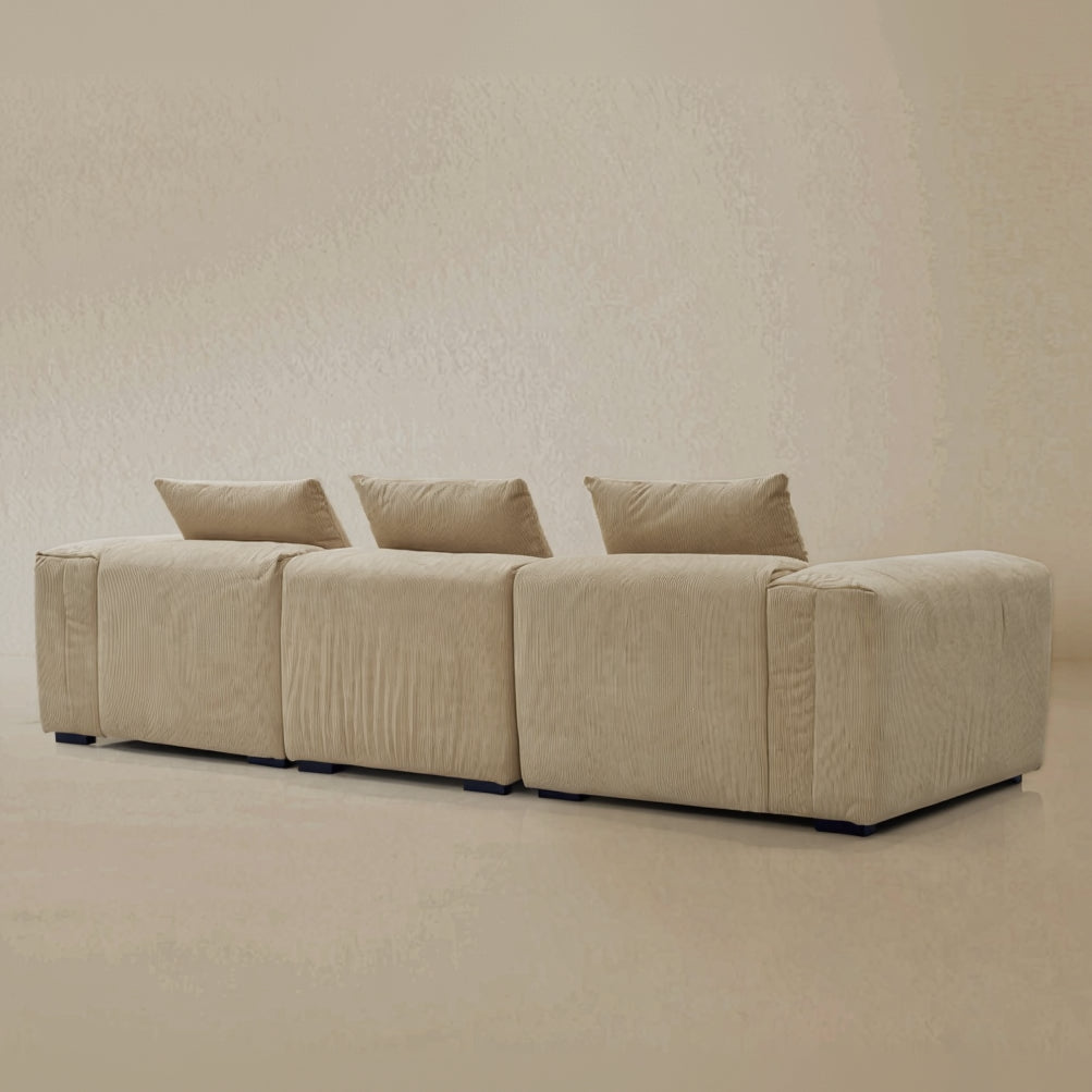 back view of the beige plush corduroy modular sofa in a studio background