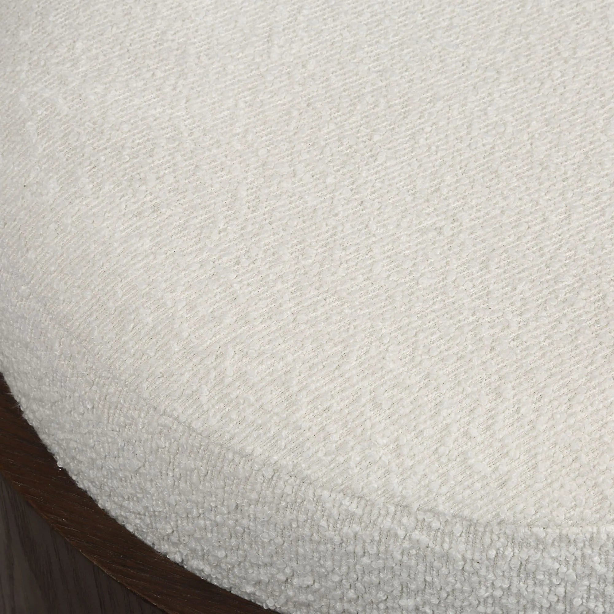 Macro close-up of the soft, nubby white bouclé fabric texture on the top seat of the Rondo round vanity stool.