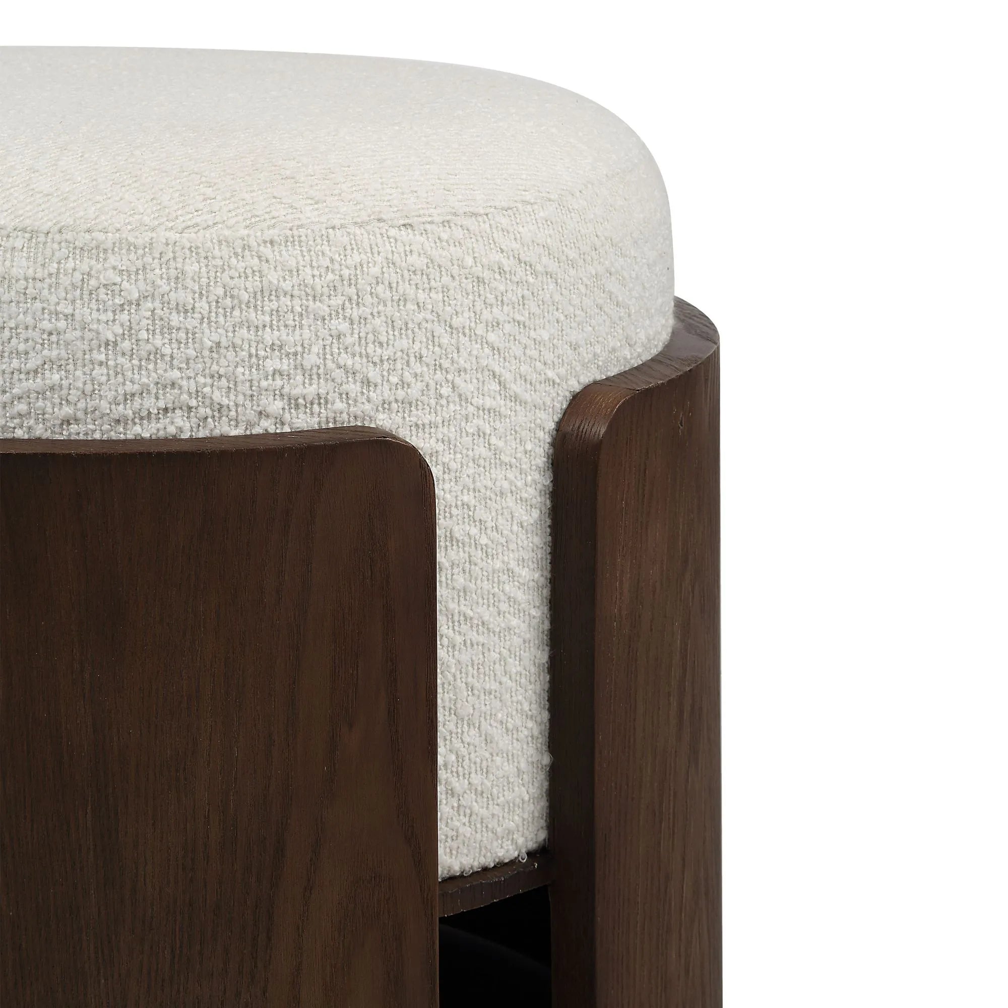 Close-up of the Rondo stool highlighting the modern dark wood frame wrapping seamlessly around the thick white textured bouclé cushion.