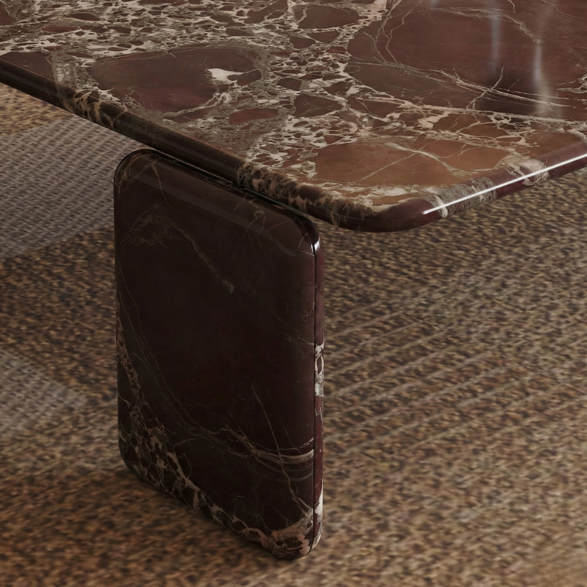 Close-up macro detail of the Rosso Forma coffee table showing the seamless bullnose edge and pill-leg marble construction.