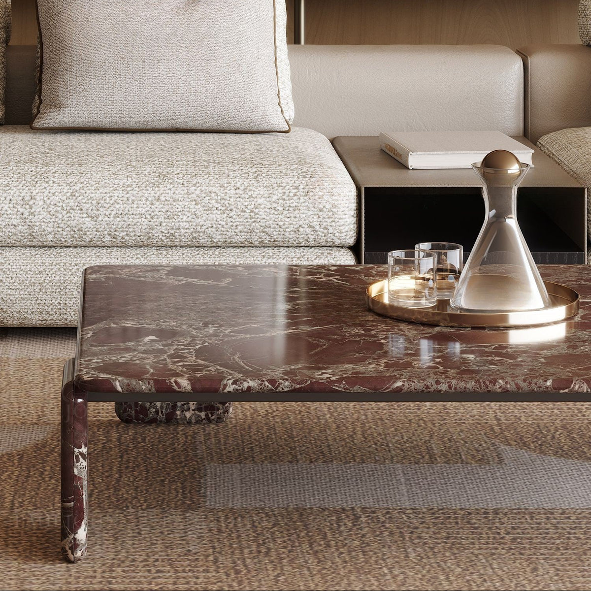 The Rosso Forma coffee table styled in a luxury living room with a gold tray and crystal decanter on a textured brown rug.