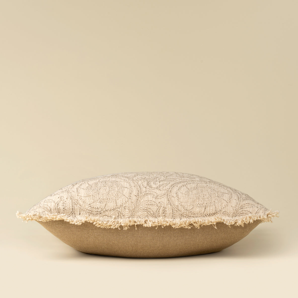 Decorative pillow with lace trim on a beige background