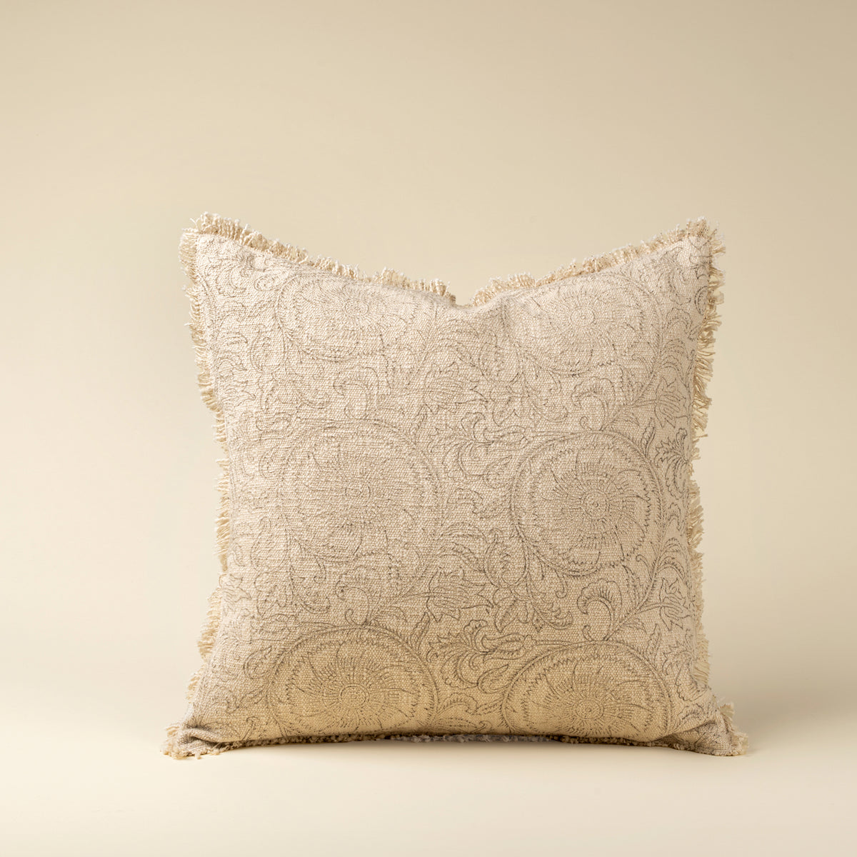 Decorative pillow with intricate patterns on a beige background