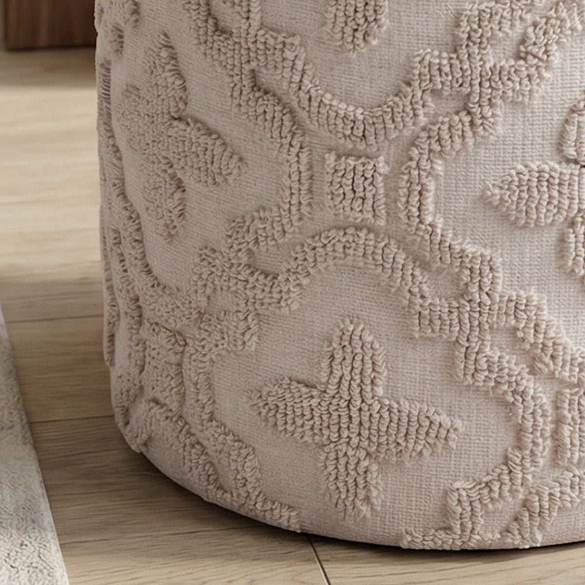Textured beige ottoman on a wooden floor