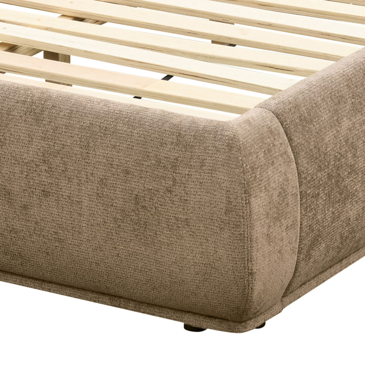 Close-up of the Serelle Upholstered Bed's rounded dark beige frame corner, stitching, wooden slats, and short support foot.