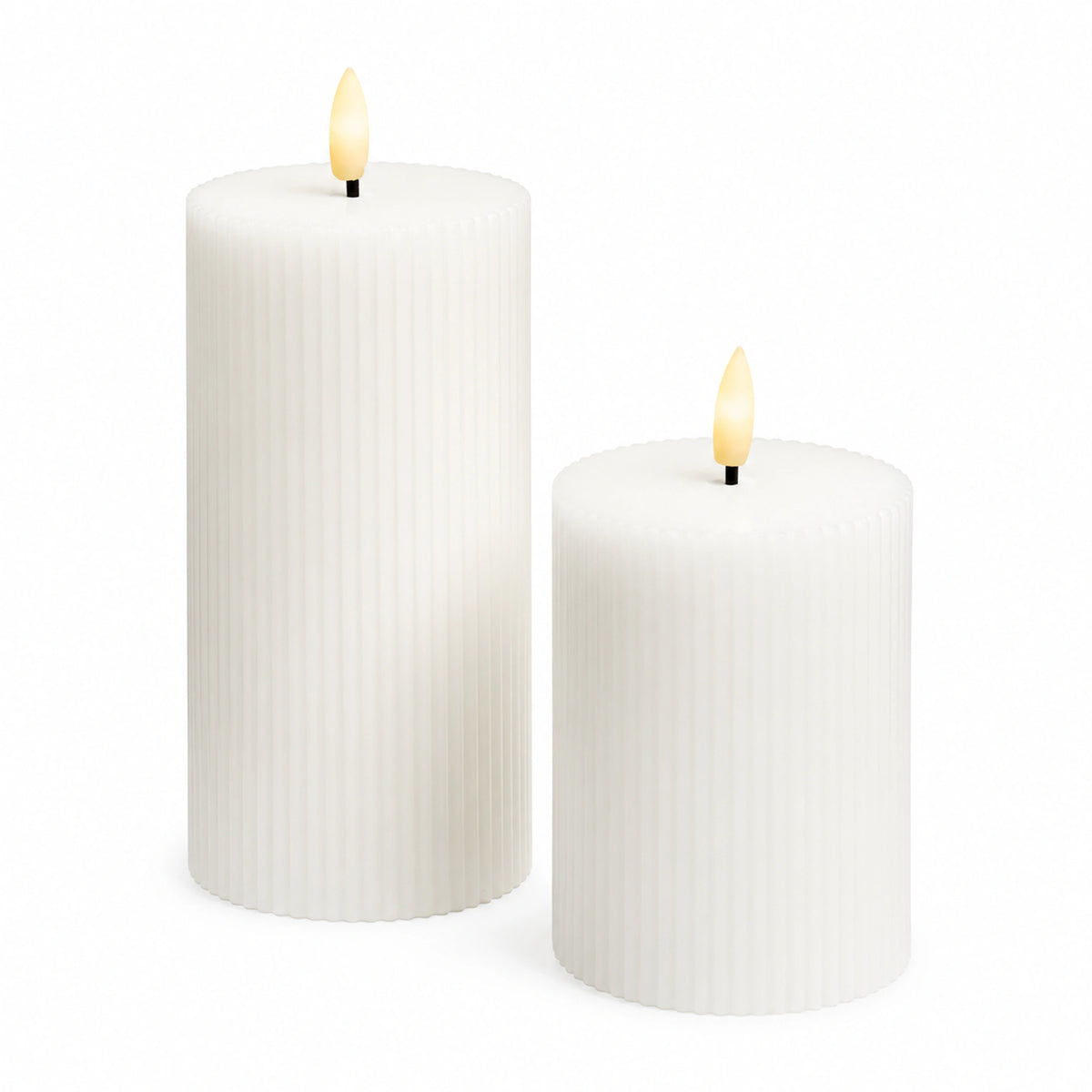 Seren tall and short white ribbed LED pillar candles with warm glowing flames on a white background.