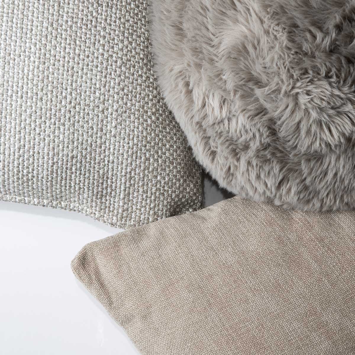 Macro detail shot showcasing the contrast between the linen, textured weave, and plush faux fur fabrics of the Serenity trio.