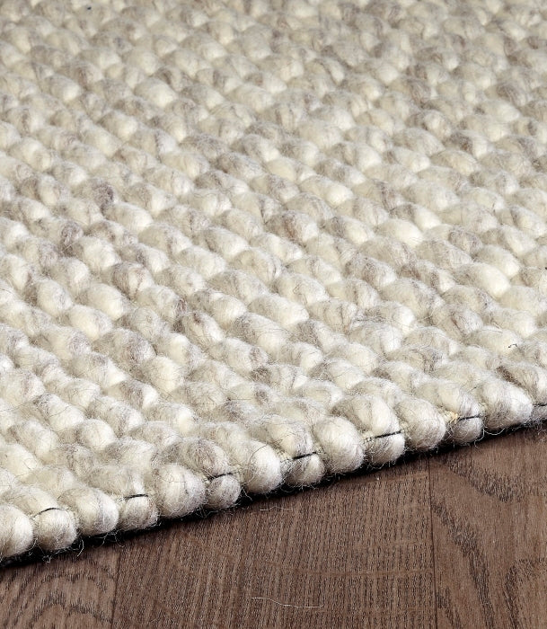 Detailed close-up of the chunky looped pile on the cream ivory Silas hand-woven wool rug