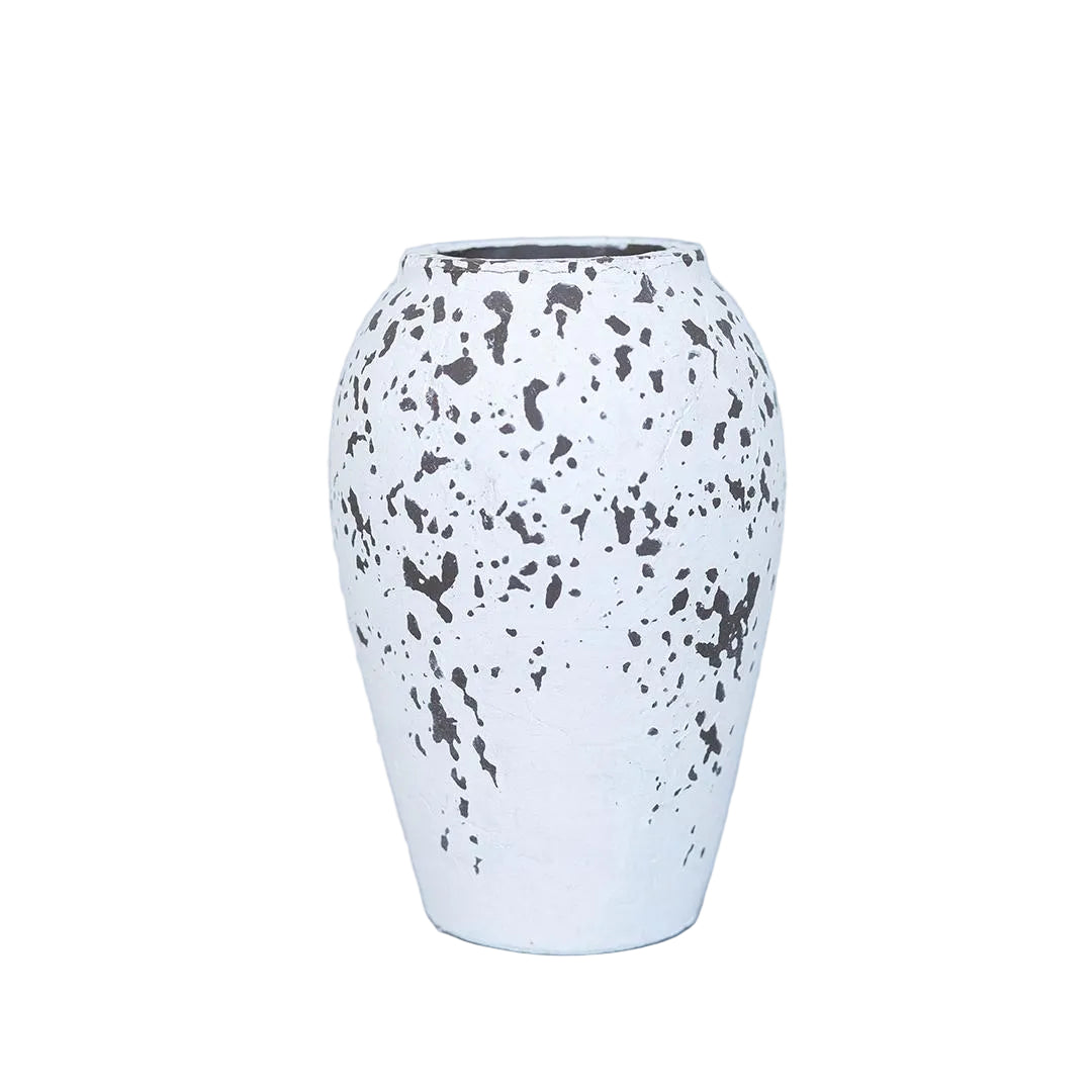 White vase with black speckles on a light gray background