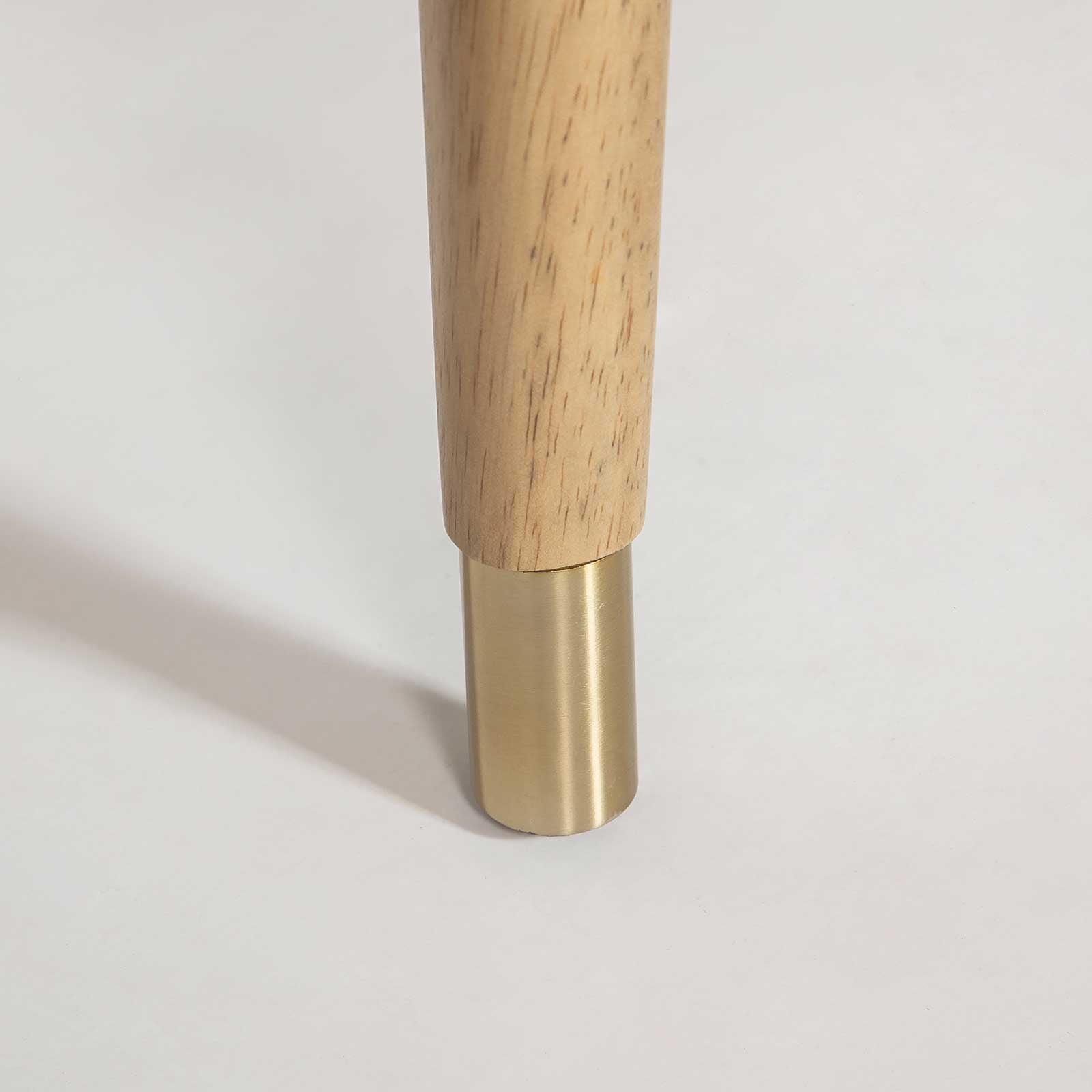 Close-up of the Sterling counter stool base featuring blonde wood legs, brushed brass ferrules, and a matching metal footrest bar.