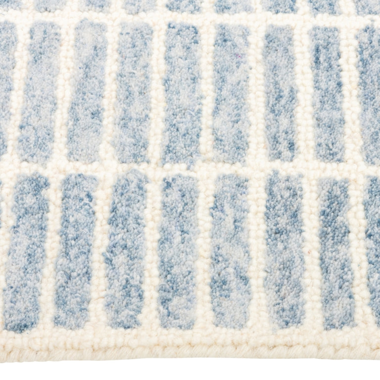Close-up of the Tessera Hand-Tufted Wool Grid Rug in blue showing its soft wool pile and ivory grid lines.