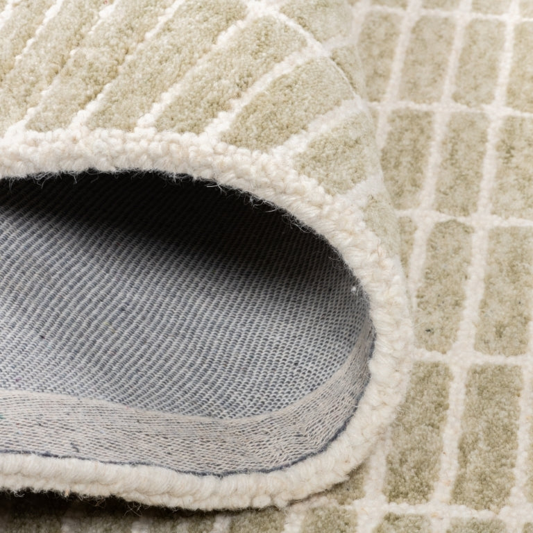 Folded Tessera Hand-Tufted Wool Grid Rug in sage showing the wool pile, bound edge, and cotton backing.