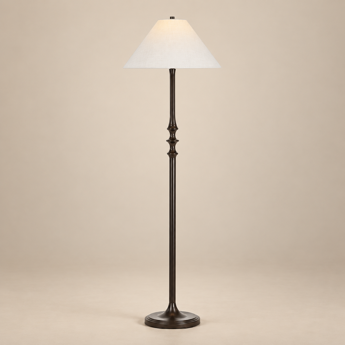 Thalia Dark Bronze Floor Lamp with a sculpted iron stem and off-white linen shade on a seamless beige studio background.