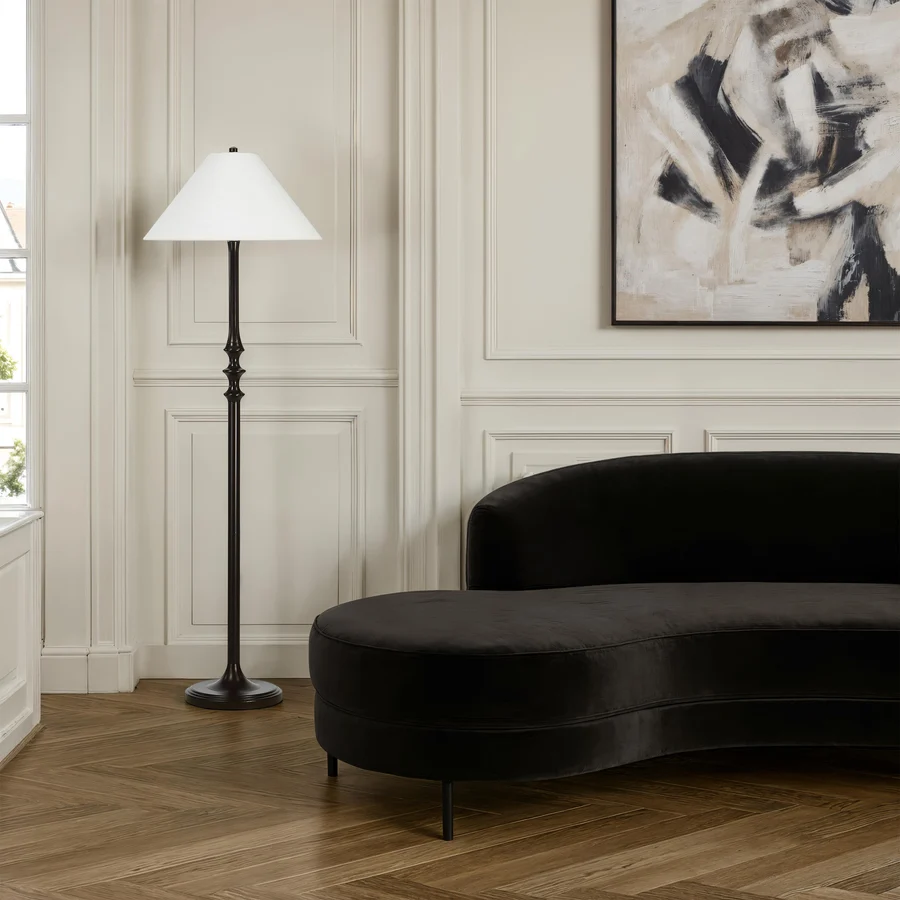 Thalia Dark Bronze Floor Lamp styled beside a black curved sofa in an elegant living room.